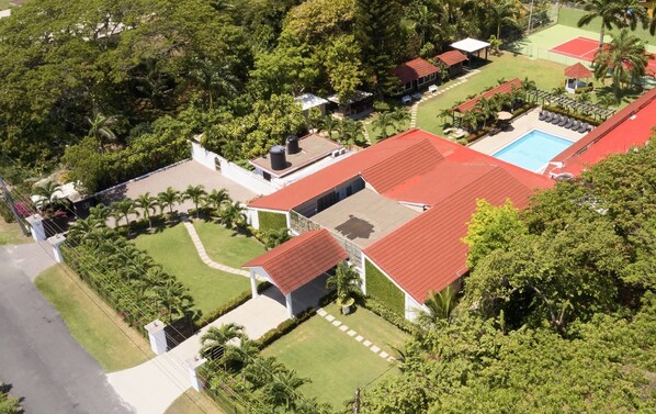 Un quartier résidentiel comprenant plusieurs maisons, une piscine et un court de tennis.