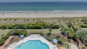A pool area with a view of the beach and ocean. - Station One - 8I From - Oceanfront condo with community pool, tennis, beach (Wrightsville Beach)