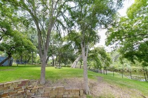Un parque con árboles, una mesa de picnic y un muro de ladrillo.