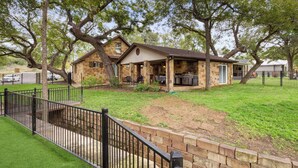 A stone house with a covered patio and barbecue area.