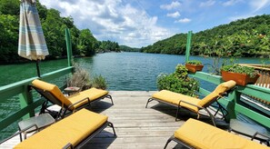 A wooden deck with yellow cushioned chairs and a green railing overlooking a calm river. - This House Is Lake Summit, Truly Original but with all the Modern Amenities (Saluda)