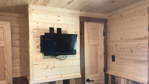 Una habitación con paneles de madera y un televisor de pantalla plana montado en la pared.