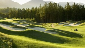 A golf course with undulating terrain and sand bunkers.