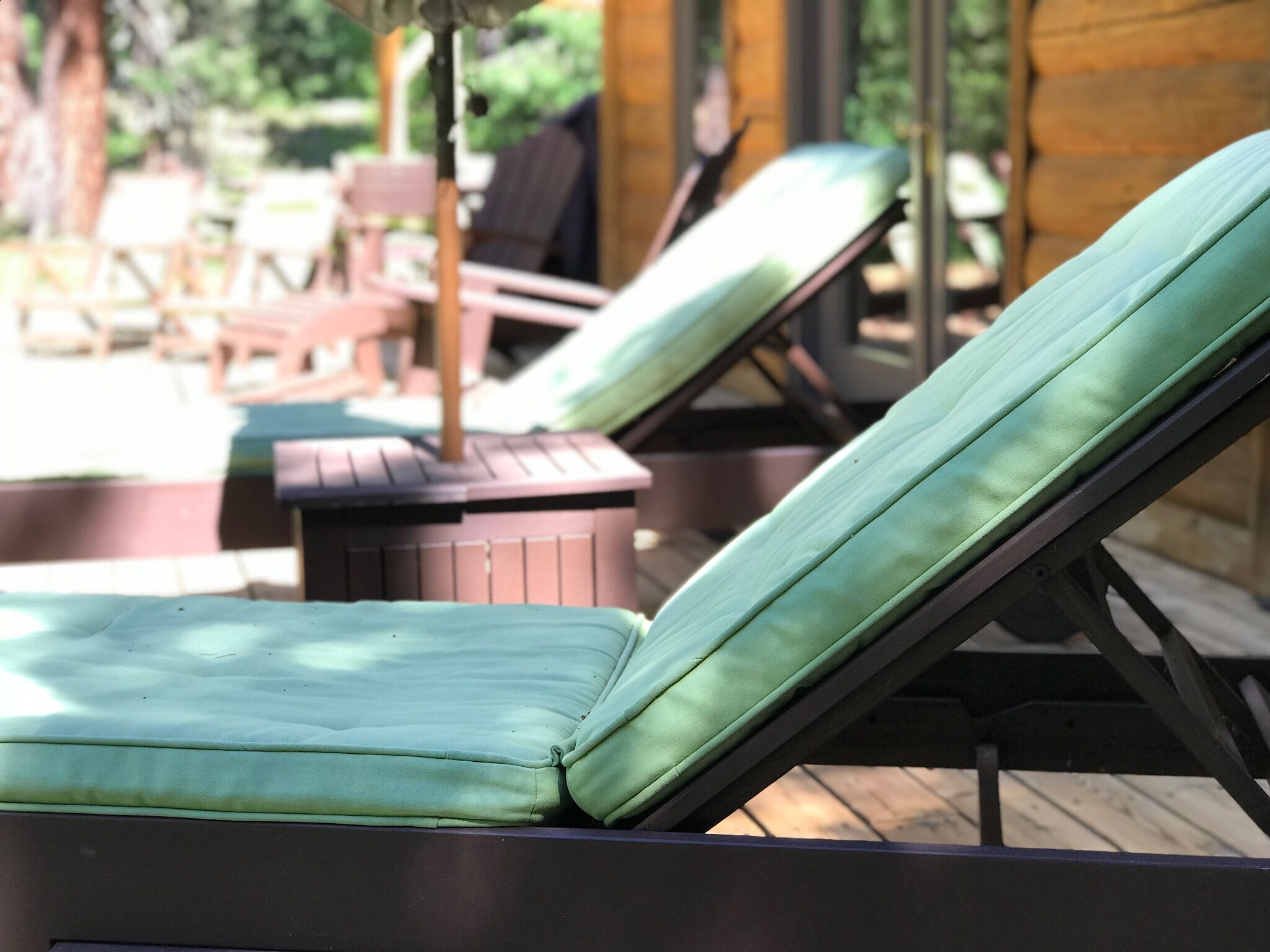 A poolside area with lounge chairs and a wooden deck.
