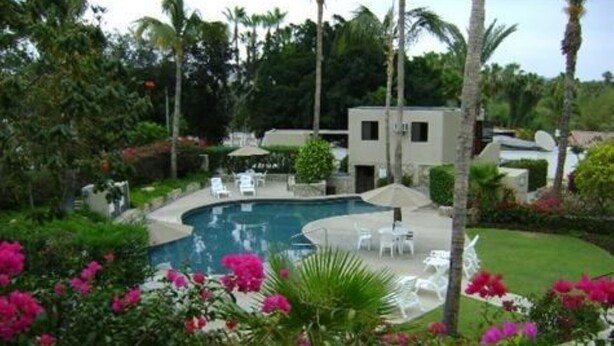 A swimming pool surrounded by lush greenery and white lounge chairs. - Beautiful Remodeled Condo near DownTown and Beach in San Jose del Cabo. (San Jose del Cabo,B.C.S.23406)