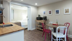 A compact hotel room with a kitchenette, a dining area with a table and chairs, and a bed in the adjacent room. - Charming H St Oasis close to Capitol and museums (Washington)