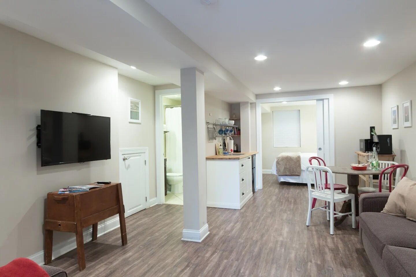 A compact living space with a TV, a dining area, and a kitchenette.