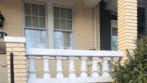 A two-story building with a white balcony and a small entrance. - Charming H St Oasis close to Capitol and museums (Washington)