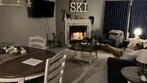 Una sala de estar con chimenea, una mesa de comedor y un sofá.