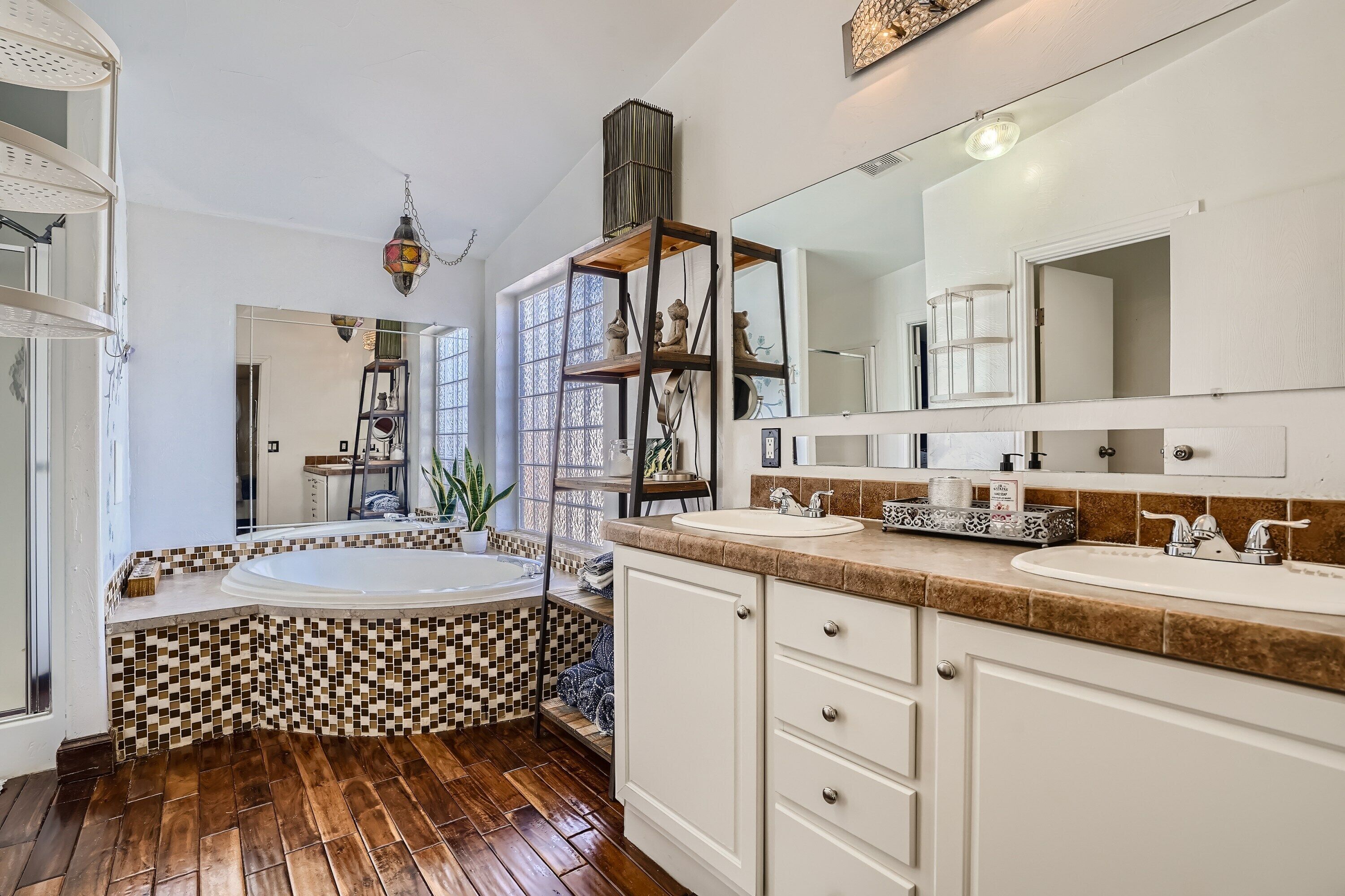 Une salle de bain moderne avec une baignoire sur pieds, un grand miroir et un meuble-lavabo.