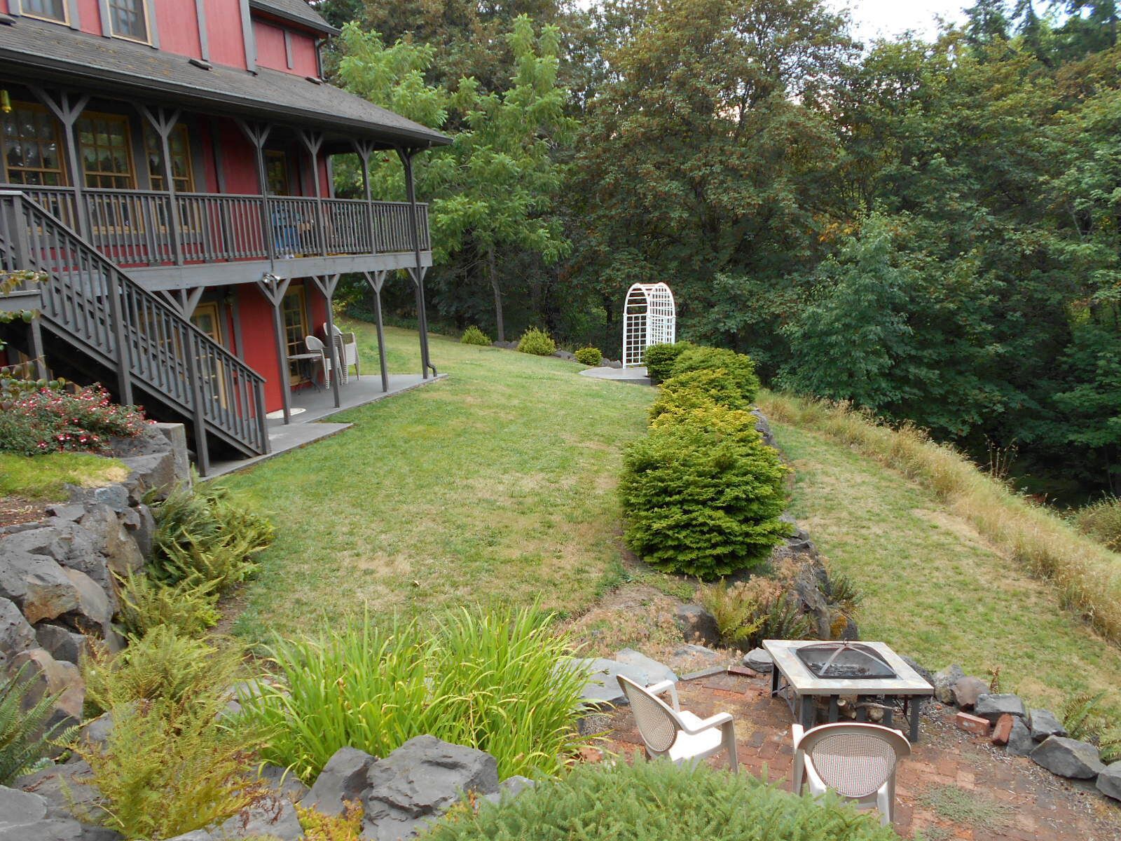 A house with a porch, a fire pit, and a small garden.