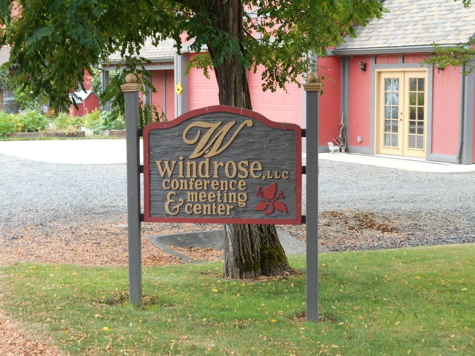Een bordje voor Windrose Conference & Meeting Center, met een boom op de voorgrond.