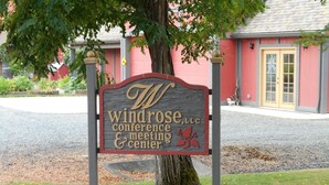 Une enseigne indiquant le centre de conférences et de réunions Windrose, avec un arbre au premier plan.