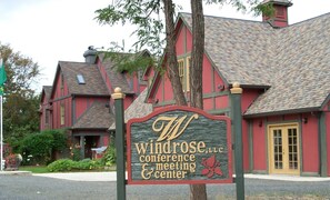 A building with a sign reading "Windrose, LLC conference & meeting center".