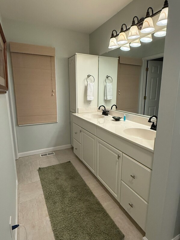 A bathroom with a double sink, a large mirror, and a towel rack. - Beautiful 3 bdrm 2.5 bath ranch on the 3rd fairway of Cougar Point Golf Course. (Kiawah Island)