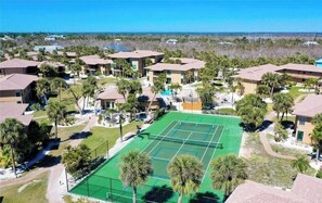 Un quartier résidentiel composé de plusieurs maisons à deux étages, d’un court de tennis et d’une piscine.
