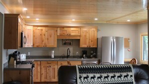Una cocina con armarios de madera, un refrigerador y una estufa.