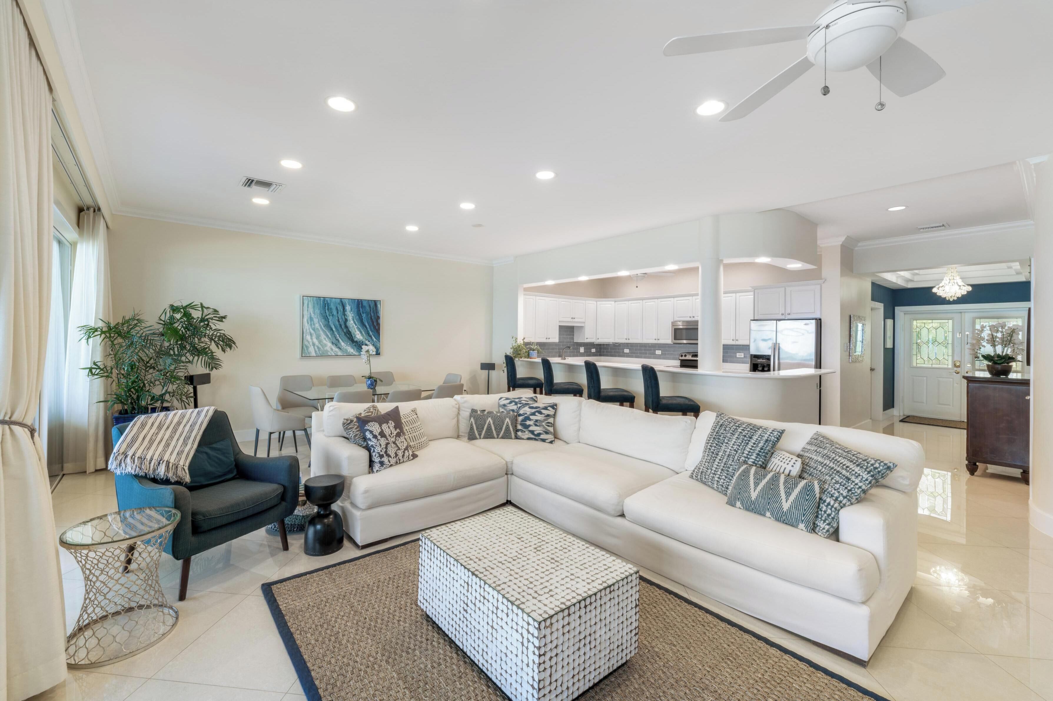 A modern living room with a sectional sofa, a coffee table, and a dining area with chairs.