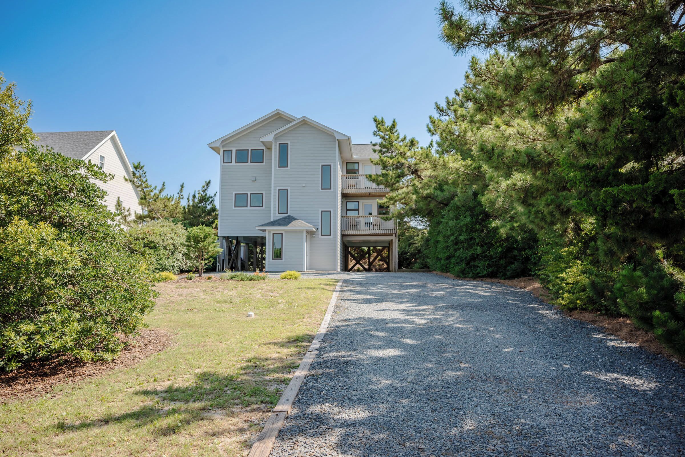 A two-story house with a gravel driveway and a garage.