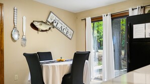 A dining area with a table set for two, a fish mounted on the wall, and a sign that reads "Welcome to Our PLACE." - Boomer Bed & Bass; 2 bedroom, 2 bathroom family cabin. (Broken Bow)