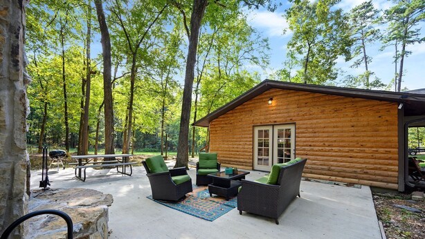 A log cabin with outdoor seating and a picnic table. - Boomer Bed & Bass; 2 bedroom, 2 bathroom family cabin. (Broken Bow)