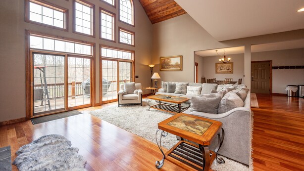 A spacious living room with a high ceiling, large windows, a fireplace, and a cozy seating area. - Luxury Mountain Escape w/ Community Perks (McHenry)