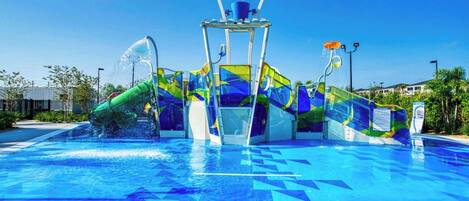 A swimming pool with a colorful slide and water features.