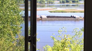 Vista de un río con esclusas, rodeado de vegetación y colinas.