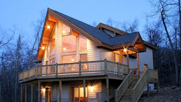 A wooden cabin with a balcony, large windows, and a staircase leading to the main entrance. - "SERENITY 4 ALL SEASONS" (Wintergreen Resort)