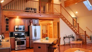 A spacious kitchen with high ceilings, a wooden staircase, and a skylight. - "SERENITY 4 ALL SEASONS" (Wintergreen Resort)