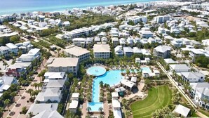 An aerial view of a resort with a central swimming pool, multiple buildings, and a coastline. - Beautiful Home at the Front of Seacrest- 3 Bikes (Panama City Beach)