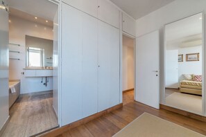 A modern bedroom with a large wardrobe, a bedside table, and a mirror.