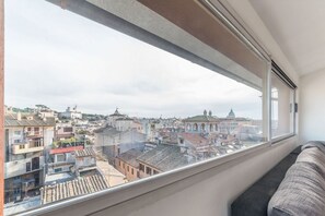 A room with a large window overlooking a cityscape.