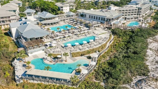 A resort with multiple swimming pools, a beach area, and a variety of buildings.
