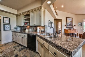 A kitchen with granite countertops, a dishwasher, and wooden cabinets. - Private Poolside Desert Oasis, fun in the sun (Santa Clara)