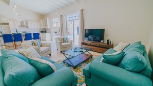 A spacious living room with teal sofas, a glass coffee table, and a flat-screen TV. - 5 BDR, 6 BATH LUXURY VILLA WALK TO RITZ , MARRIOTT & PALM BEACH (Noord)