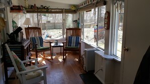 Una habitación acogedora con dos mecedoras, una mesita y un radiador.