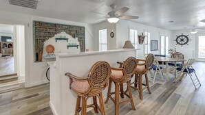 Une cuisine spacieuse dotée d’un îlot central, de tabourets de bar et d’une table à manger avec des chaises.