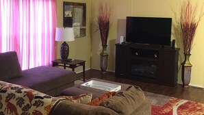 A living room with a sofa, a TV, and two vases. - Country Living with a Twist (Bolivia)