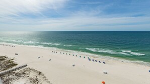 A beach with a row of umbrellas and a sandy path leading to the water. - Phoenix IX PREMIUM 2 Bedroom **BEACH FRONT!!!** (Orange Beach)