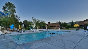 A swimming pool with lounge chairs and a small building in the background.