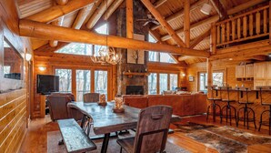 Une cabane en bois spacieuse comprenant un coin repas, un bar et une cuisine.