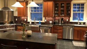 Una cocina moderna con armarios de madera, estufa de acero inoxidable y una isla grande con un jarrón de flores.