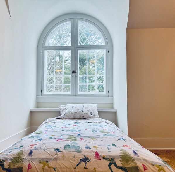 A bedroom with a bed, a window, and a view of trees. - Stunning Renovated Victorian (Great Barrington)