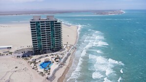A high-rise hotel with a pool and beach access, overlooking a coastal area. - Tessoro 703 - Award Winning Design at the End of Las Conchas (Puerto Penasco/Rocky Point)