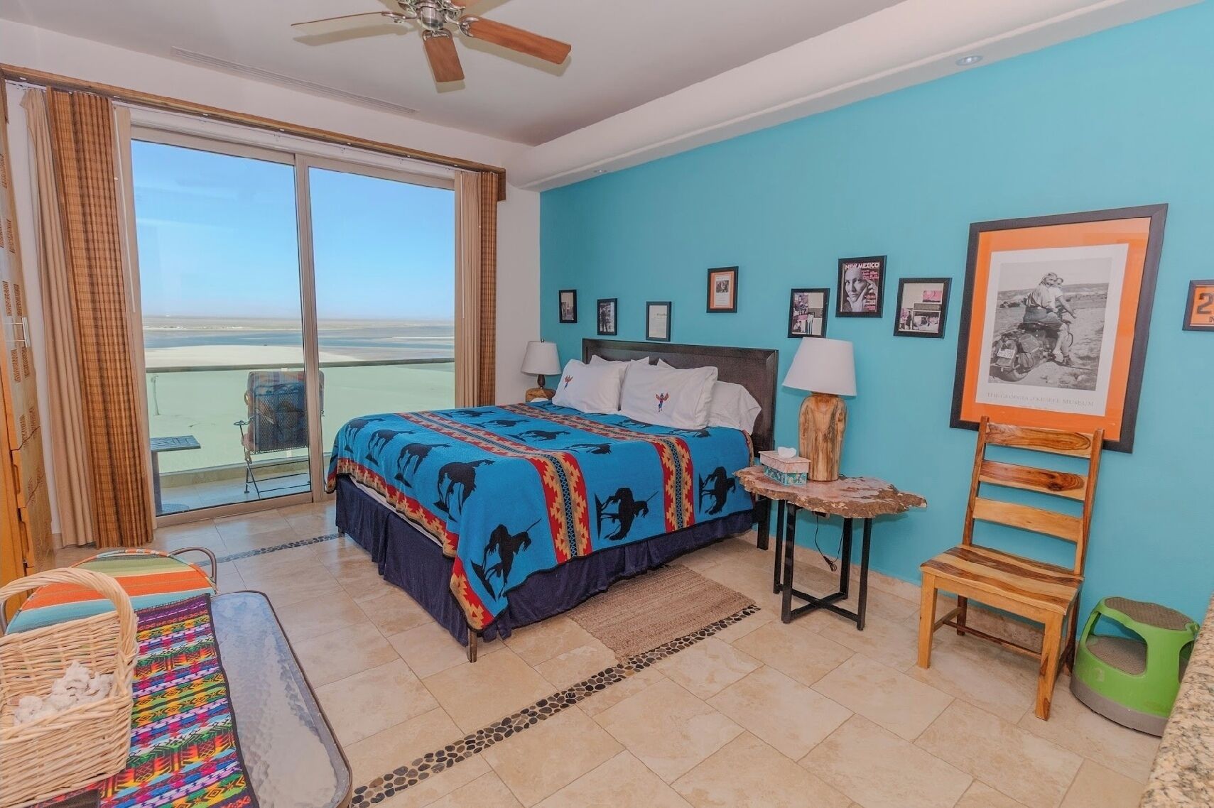 Une chambre avec un lit, une chaise, une table et un balcon offrant une vue.