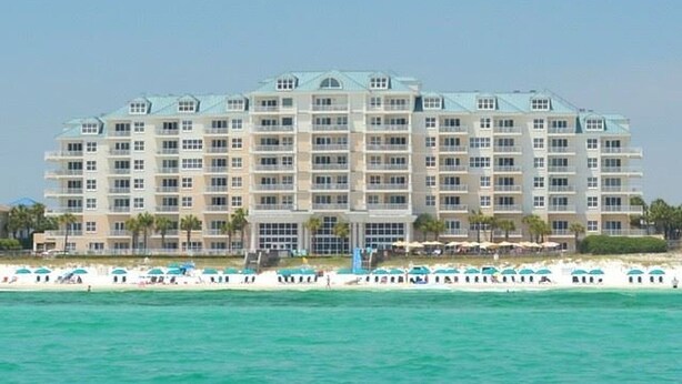 Un hotel grande con varios pisos, una entrada principal y vista al mar.