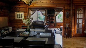 A cozy log cabin interior with a dining area, a living room, and a kitchen. - ✨Rustic Cabin in Dry Creek Valley with beautiful views // 5 miles to Plaza ✨ (Healdsburg)