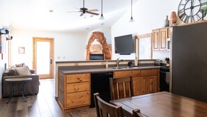 A modern kitchen with wooden cabinetry, a built-in dishwasher, and a large island with seating.