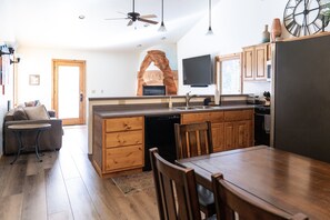 A modern kitchen with wooden cabinetry, a built-in dishwasher, and a large island with seating.